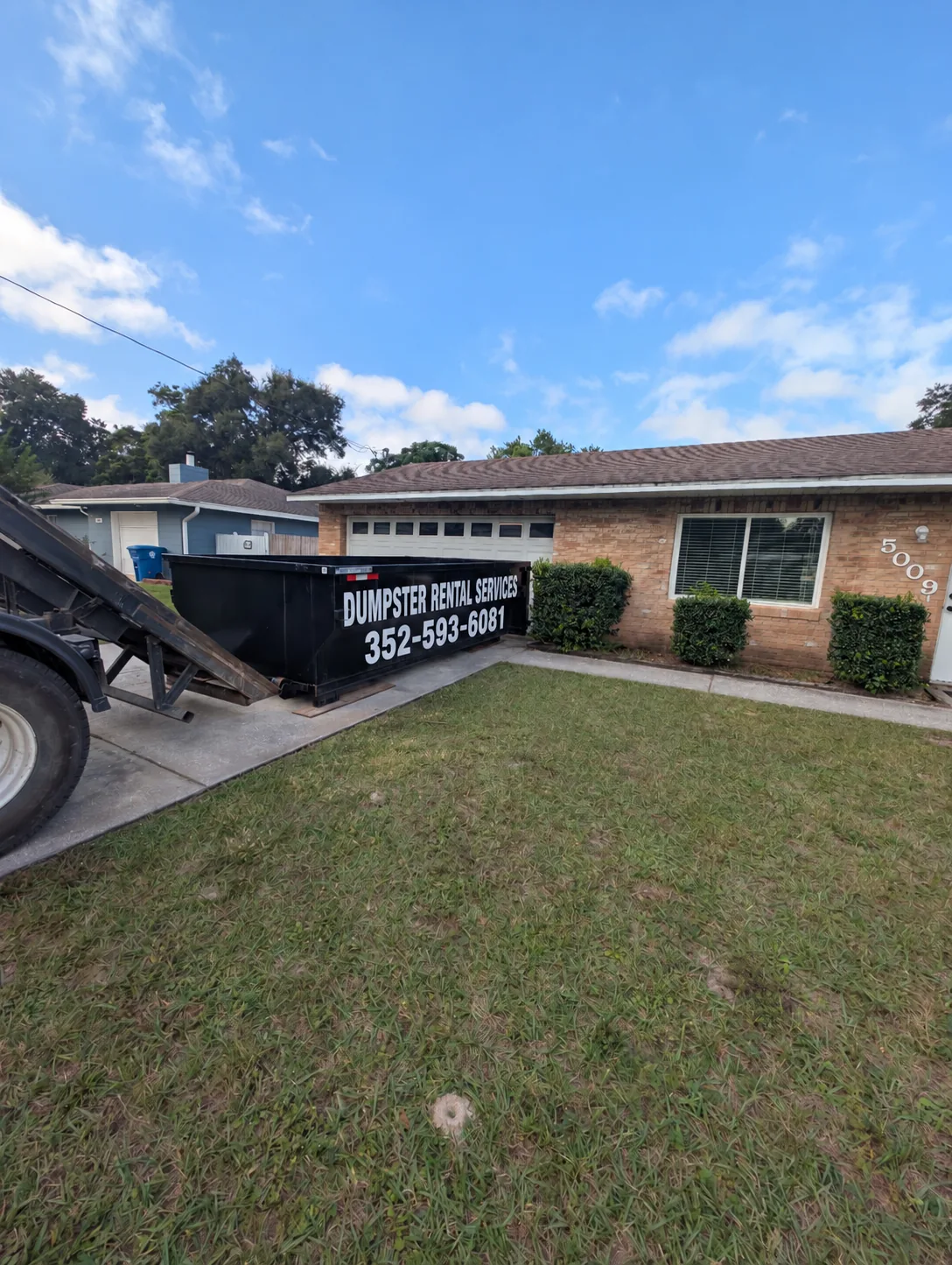 13 yard Dumpster Rental Services roll-off dumpster with 352-593-6081 lettering