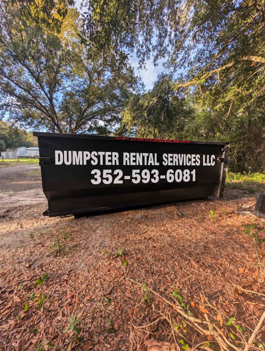 25 yard black Dumpster Rental Services roll-off dumpster with 352-593-6081 lettering
